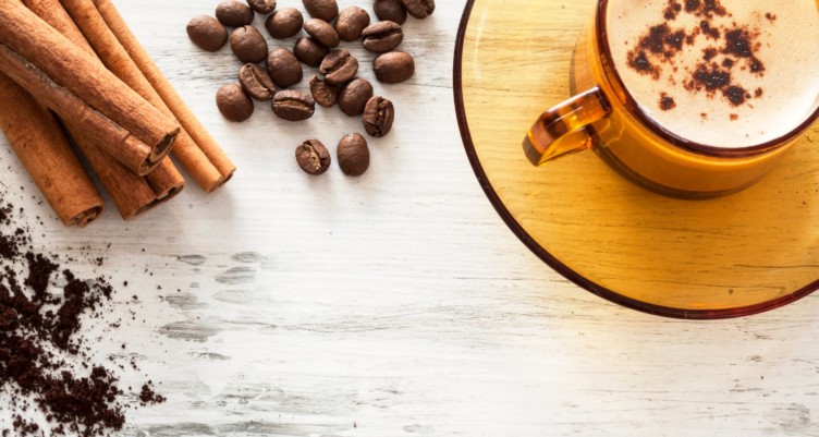 Tasse à café et haricots sur une table en bois avec des bâtons de cannelle